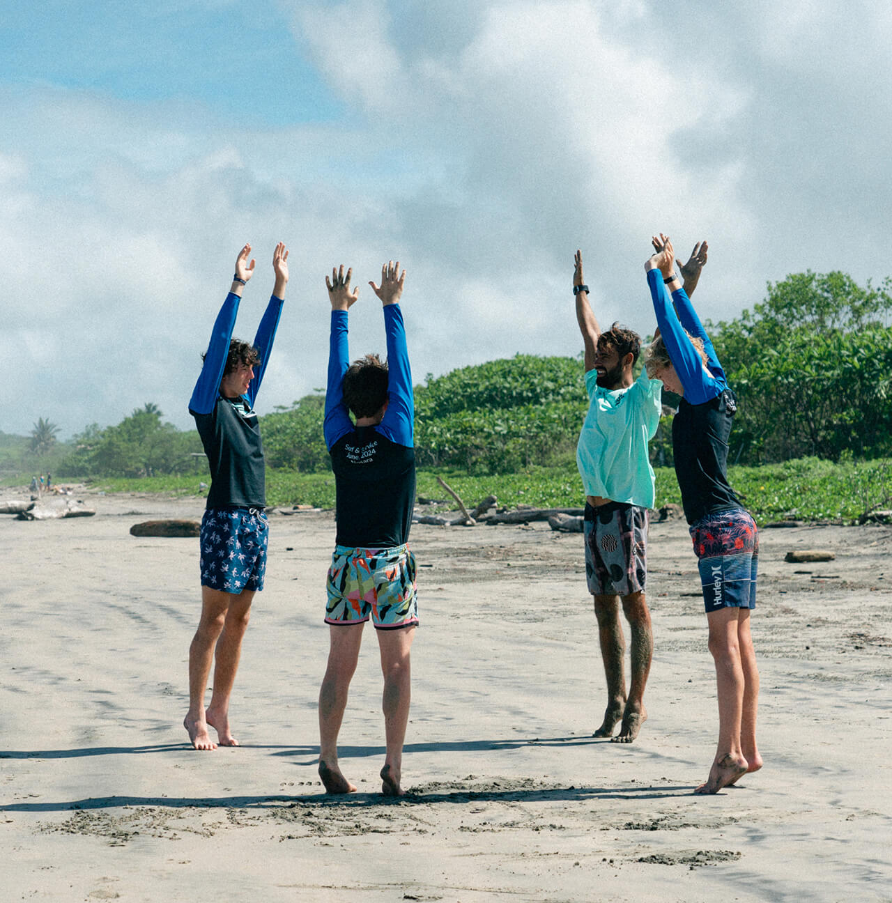 4 Discover Term attendees stretch their arms up on the beach of Costa Rica