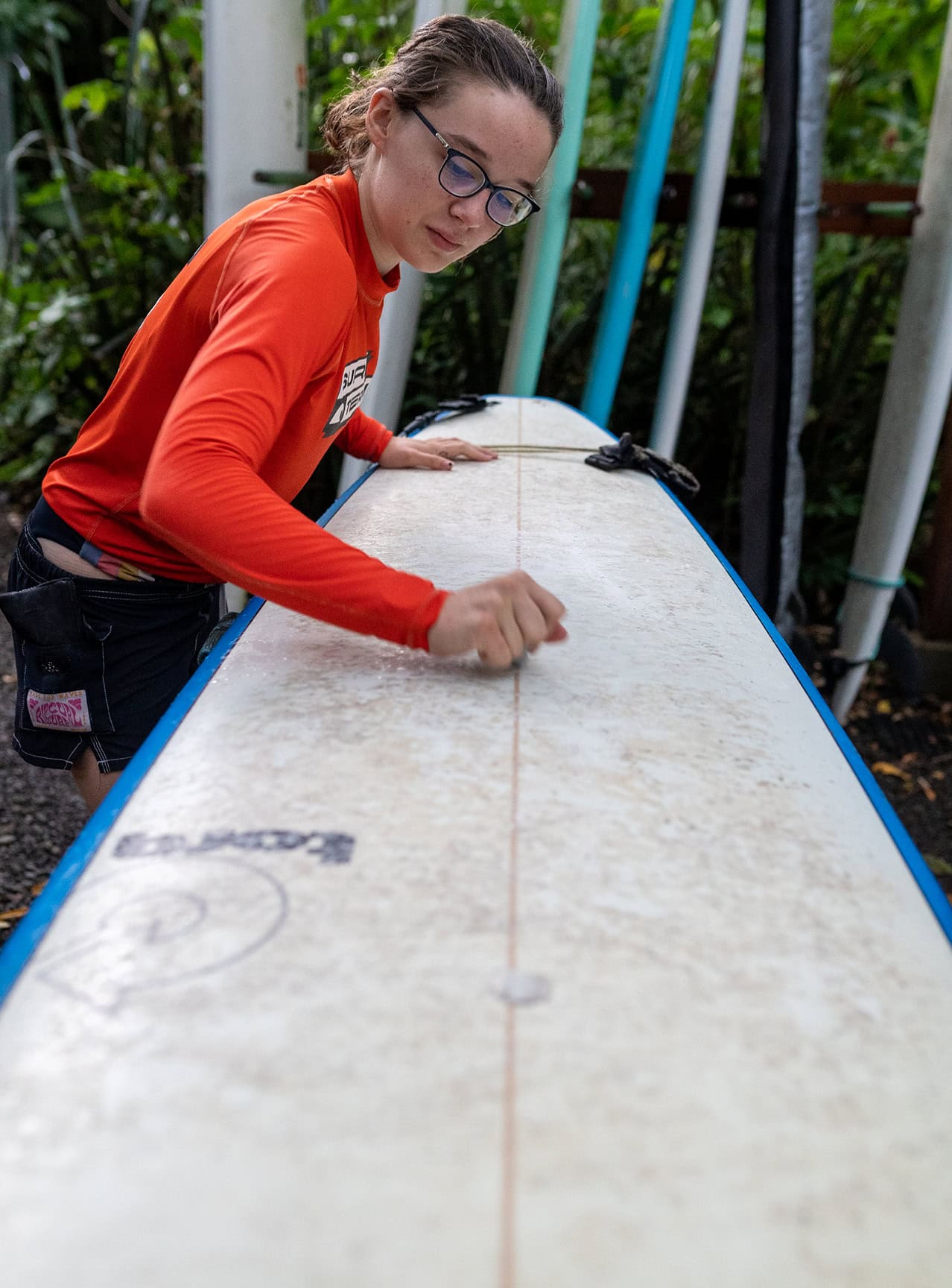 Surf Term student waxes her surfboard