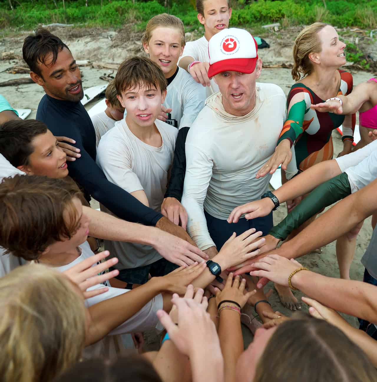 Surf & Service students putting their hands in together