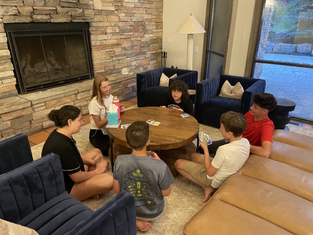 Teens unwinding at the lodge, enjoying each other’s company after a day filled with outdoor adventures and community service.